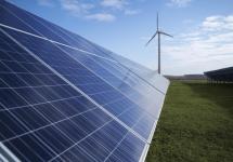 Zonnepanelen met op de achtergrond een windmolen