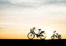 silhouetfoto van twee fietsen voor een ondergaande zon