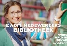 een bibliotheekmedewerker plaats een boek in een boekenrek 