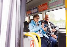 twee oudere personen zitten in een bus